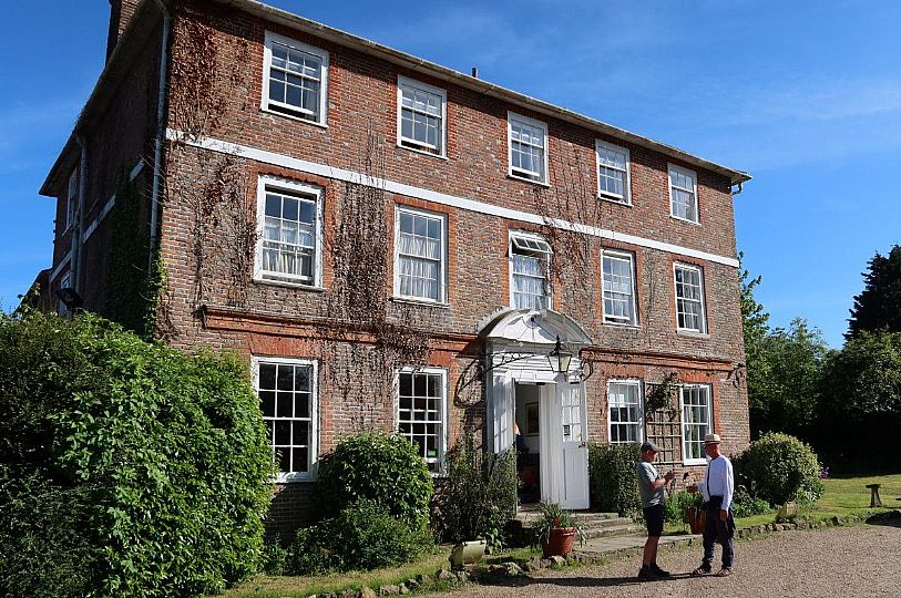 The front of Kench Hill house, with two men stood chatting in front